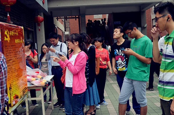 “喜迎十八大,微博寄心语”-活动现场吸引了大量学生“围观”,不少学生现场拿起手机参与寄语